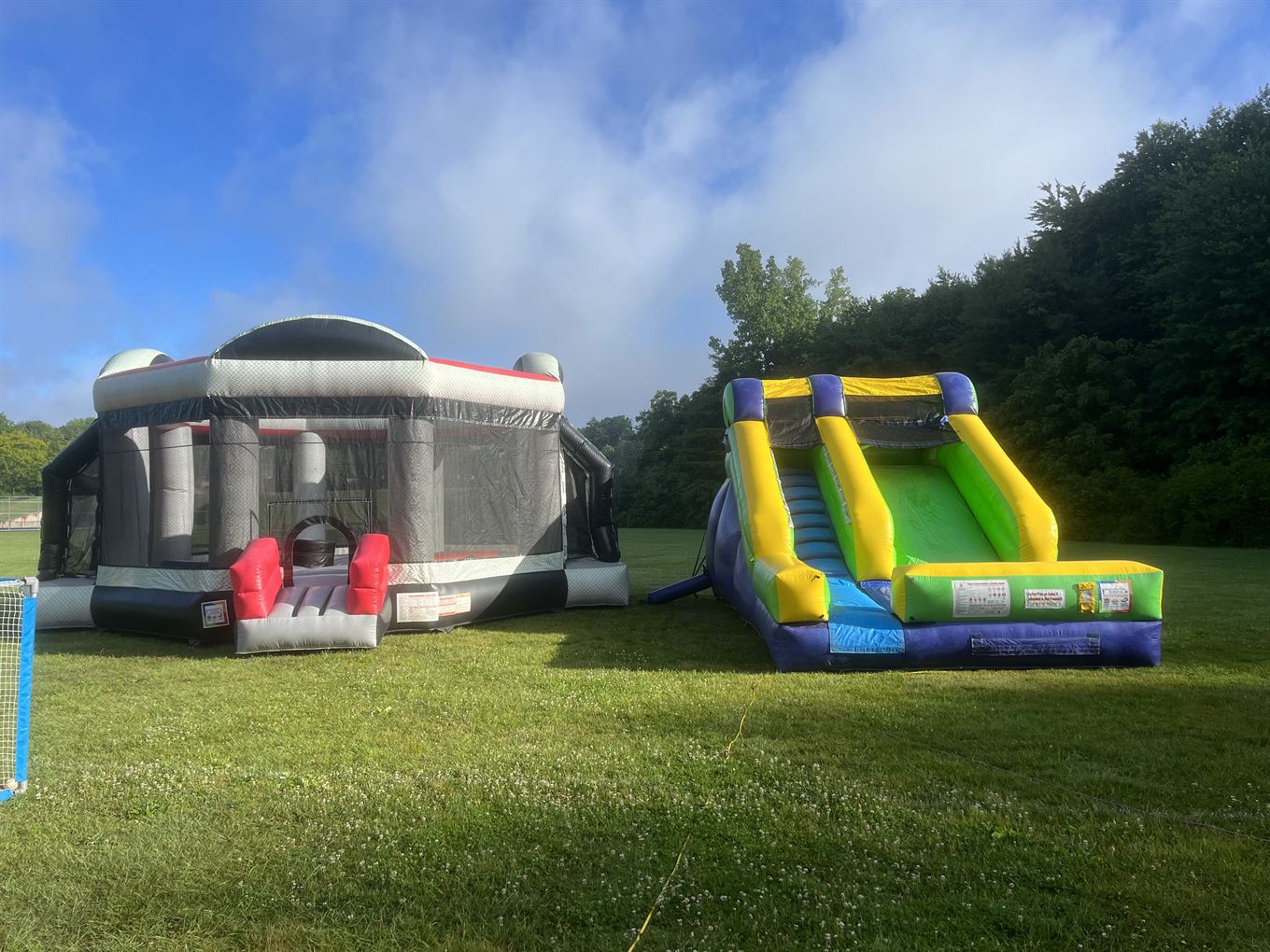 Inflatable bounce arena and slide set up on a field by K.E.C. Party Rentals